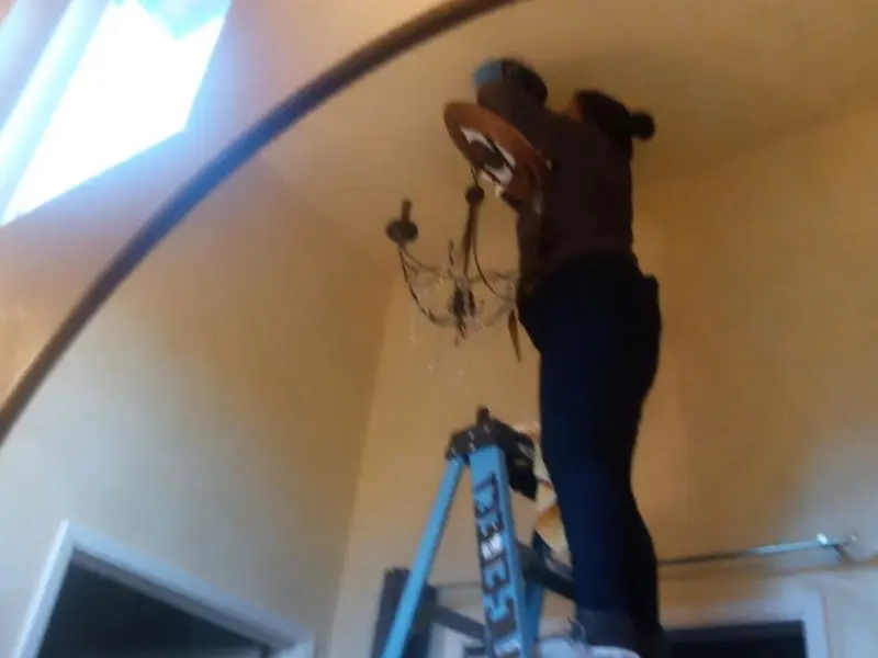 Electrician installing a chandelier in a Hilliard residence